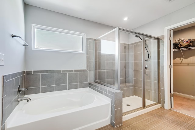 3781 Aviary Loop, Hilliard, OH 43026 - bathroom with a walk in closet, a garden tub, wood finished floors, and a shower stall