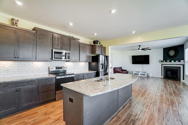 3781 Aviary Loop, Hilliard, OH 43026 - kitchen with a sink, light wood-style flooring, open floor plan, a ceiling fan, and appliances with stainless steel finishes