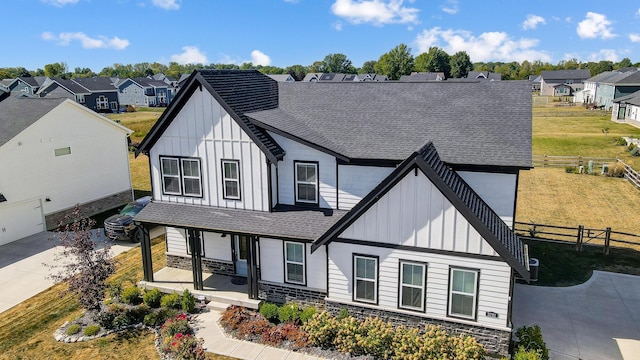 3781 Aviary Loop, Hilliard, OH 43026 - view of front facade with covered porch, board and batten siding, roof with shingles, and stone siding