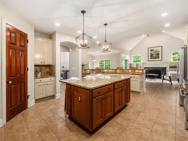 kitchen with backsplash, plenty of natural light, open floor plan, light stone counters, and recessed lighting