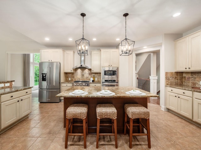 kitchen featuring appliances with stainless steel finishes, wall chimney range hood, tasteful backsplash, a chandelier, and recessed lighting