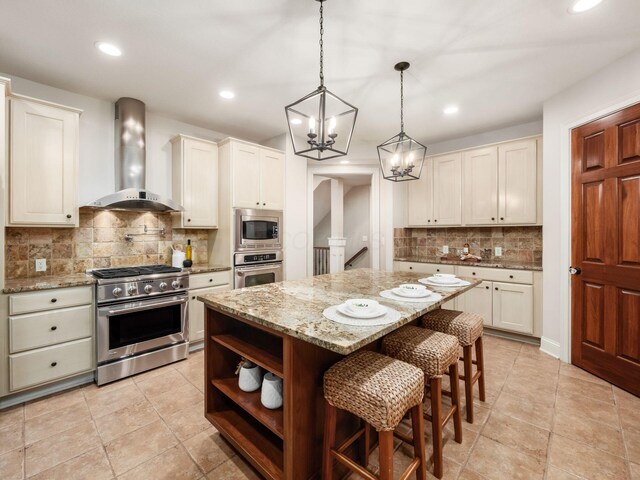 kitchen with appliances with stainless steel finishes, wall chimney range hood, backsplash, a chandelier, and recessed lighting