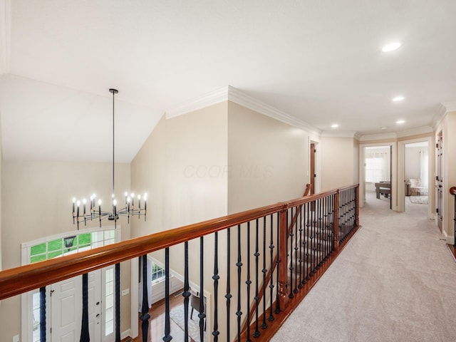 hall with an upstairs landing, recessed lighting, a chandelier, crown molding, and baseboards