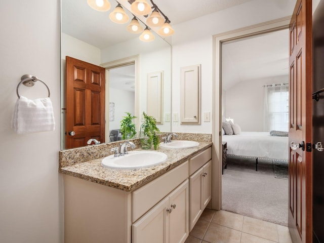 ensuite bathroom featuring double vanity, tile patterned flooring, and vaulted ceiling