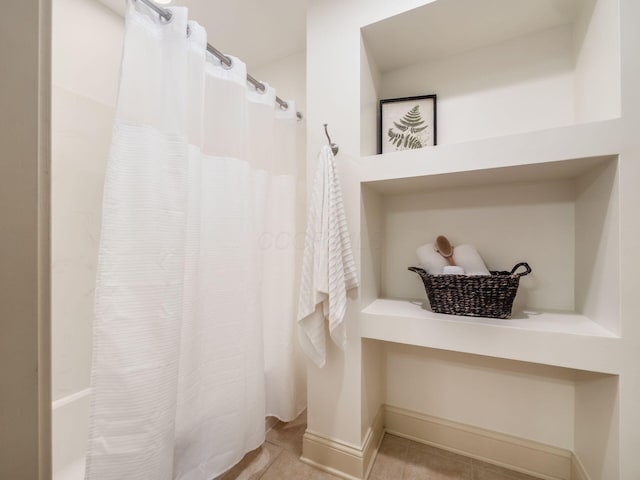 full bath with curtained shower and tile patterned flooring