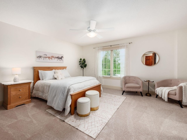 bedroom with light colored carpet, ceiling fan, and baseboards