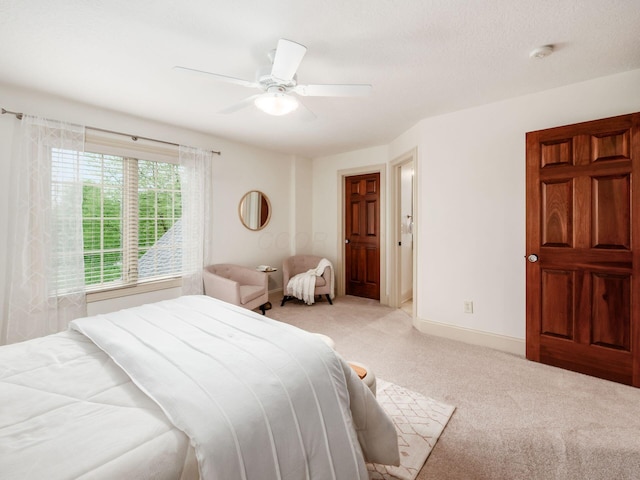 bedroom with light carpet, a ceiling fan, and baseboards
