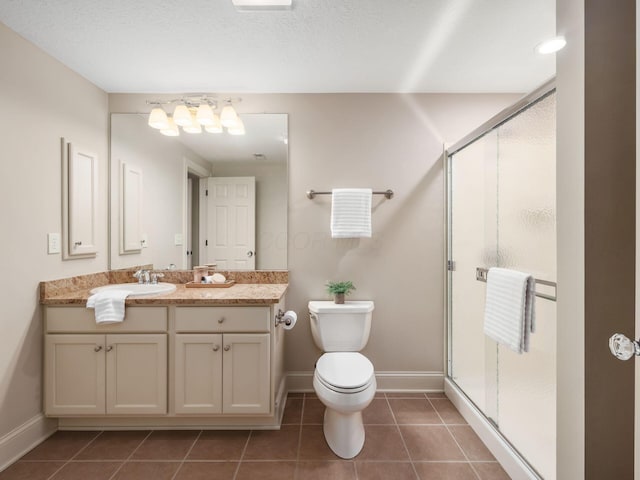 full bath with baseboards, a stall shower, tile patterned flooring, vanity, and toilet