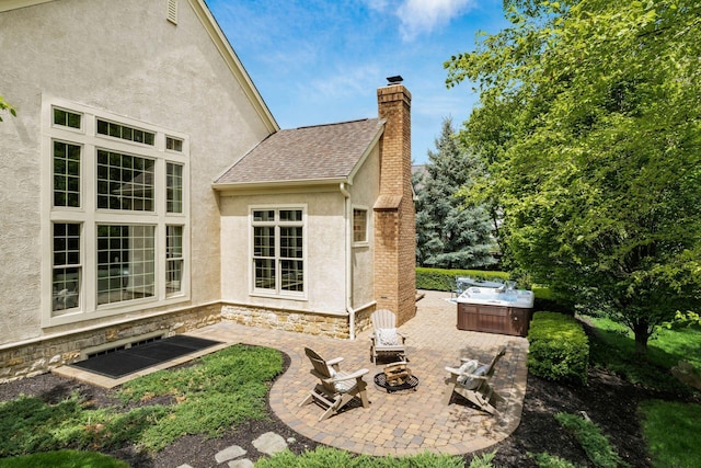 view of patio with a hot tub and a fire pit