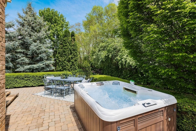 view of patio featuring a hot tub and outdoor dining area