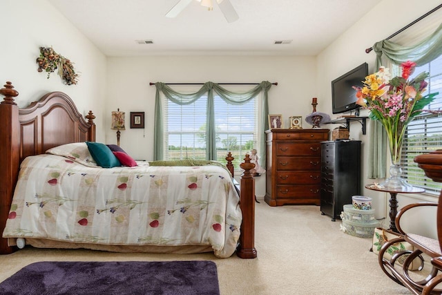 bedroom featuring visible vents, a ceiling fan, and light carpet