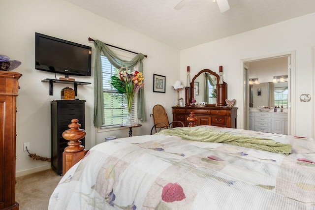 bedroom featuring ensuite bathroom, multiple windows, carpet, and a ceiling fan