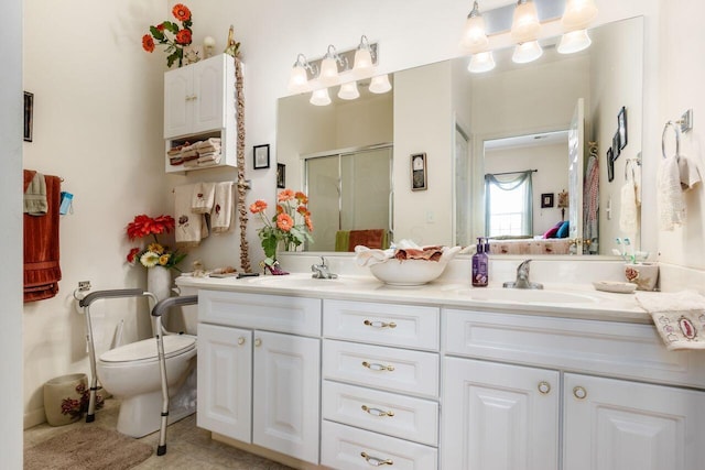bathroom with double vanity, a stall shower, a sink, tile patterned floors, and toilet
