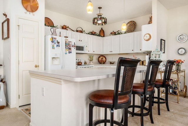 kitchen with white cabinets, light colored carpet, white appliances, light countertops, and a peninsula