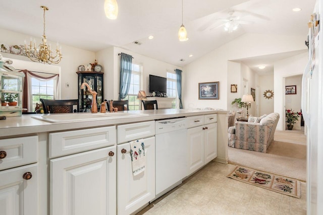 kitchen featuring lofted ceiling, light countertops, white cabinets, a sink, and dishwasher