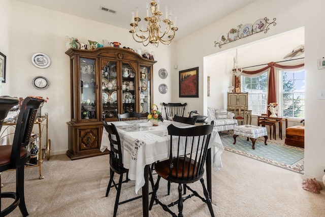 dining space featuring a notable chandelier, light colored carpet, and visible vents