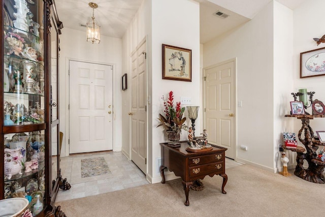 entrance foyer with baseboards, visible vents, and light carpet