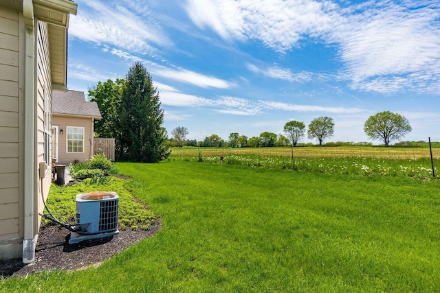 view of yard with central AC and a rural view