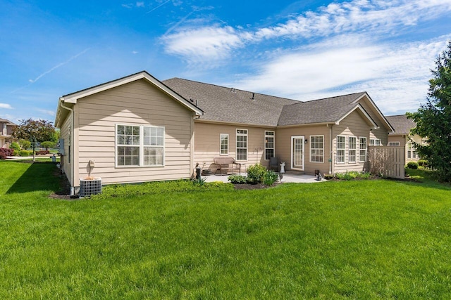 back of property with a lawn, a patio area, and central AC