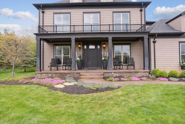view of front of home with a balcony, a porch, and a front lawn