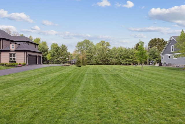 view of yard featuring a garage and driveway