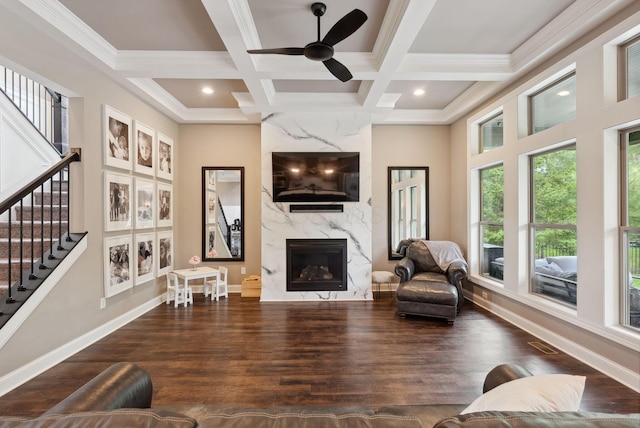 living area featuring a fireplace, ceiling fan, coffered ceiling, and visible vents