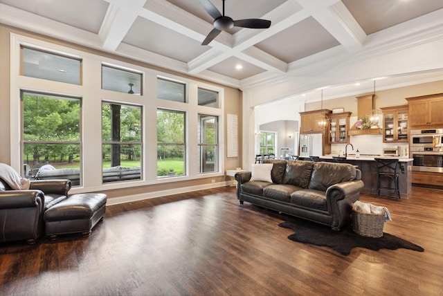 living room featuring coffered ceiling, ceiling fan, plenty of natural light, and a towering ceiling