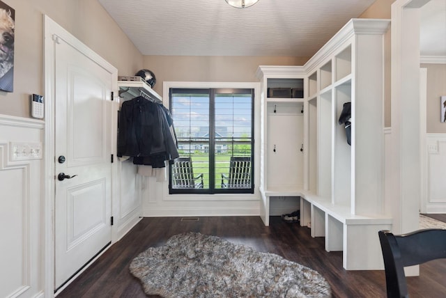 mudroom with a decorative wall and dark wood-style floors