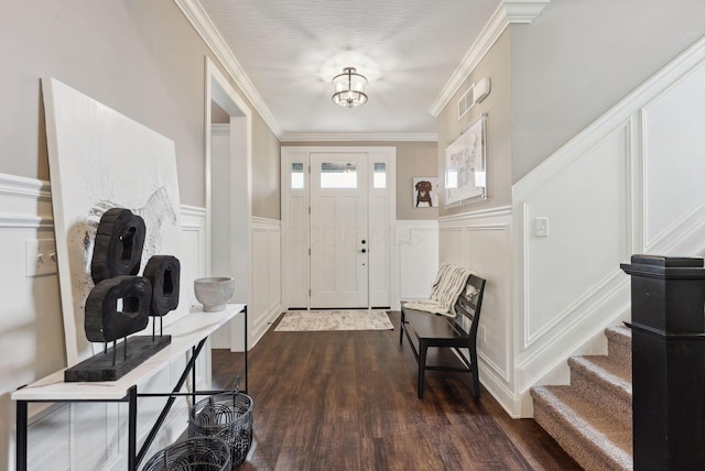 entryway featuring wainscoting, ornamental molding, a decorative wall, and dark wood-style floors