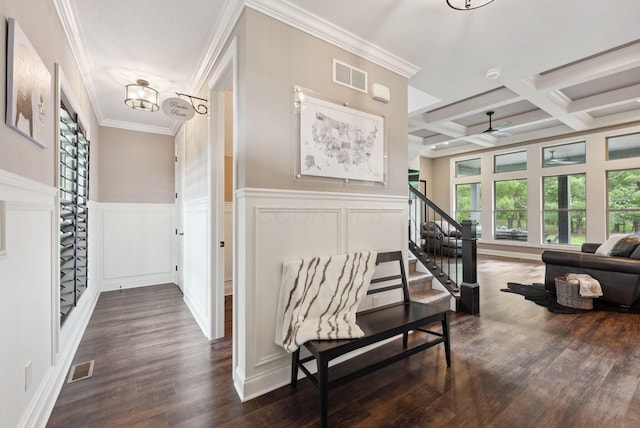 hallway with stairway, a decorative wall, dark wood-style floors, and visible vents