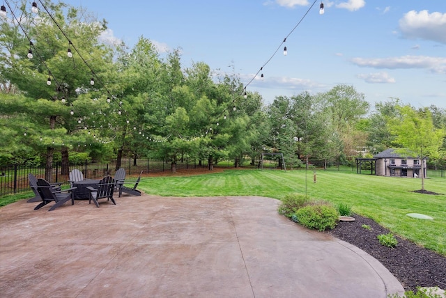 view of patio with an outdoor structure, a fire pit, and a fenced backyard