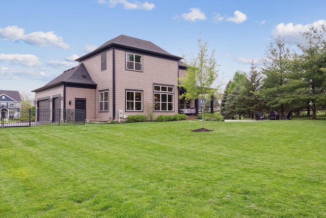 rear view of property with a yard, an attached garage, and fence