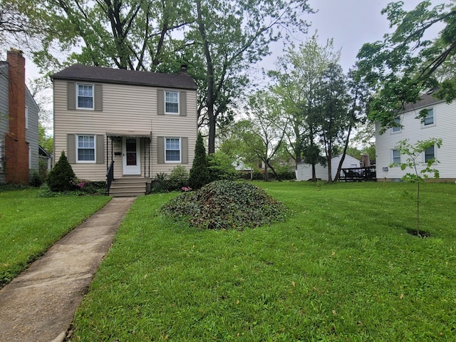 colonial home with a front yard and a chimney