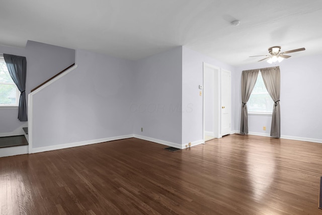 unfurnished living room with ceiling fan, healthy amount of natural light, wood finished floors, and baseboards