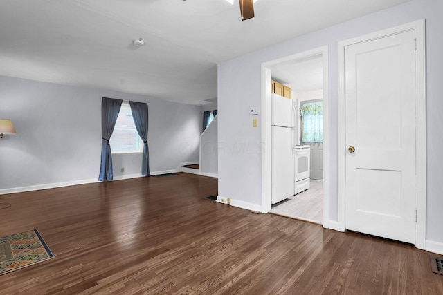 unfurnished living room with wood finished floors, baseboards, and ceiling fan