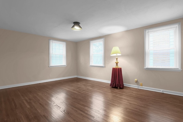 empty room with baseboards and wood finished floors