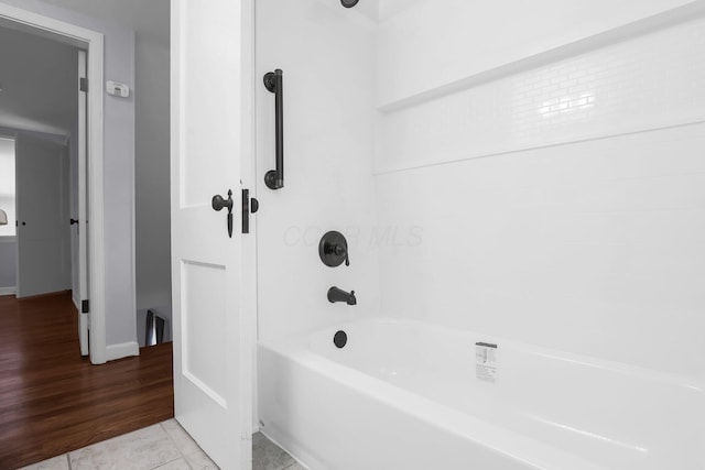 full bathroom featuring shower / washtub combination, wood finished floors, and baseboards