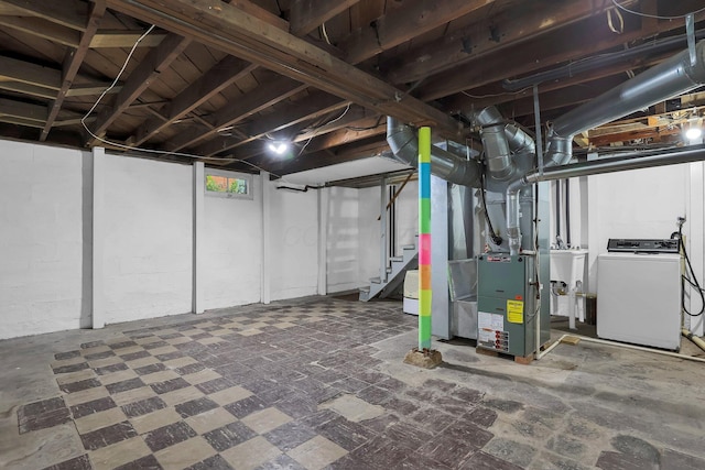 below grade area with stairs, heating unit, washer and dryer, and a sink