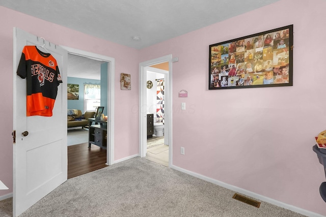 corridor with carpet flooring, baseboards, and an office area