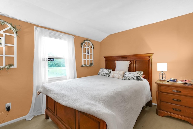 bedroom featuring light colored carpet, lofted ceiling, and baseboards