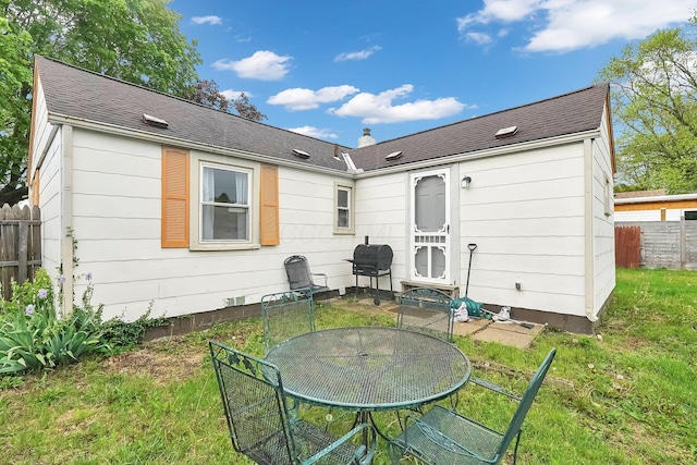 back of house featuring outdoor dining space and roof with shingles