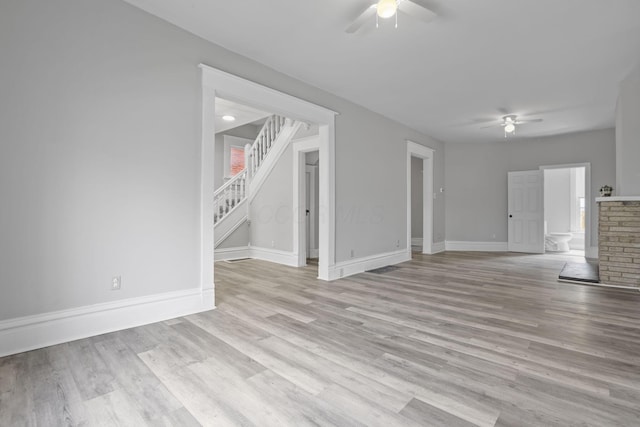 838 Wilson Ave, Columbus, OH 43206 - unfurnished living room featuring ceiling fan, stairway, light wood-style floors, and baseboards