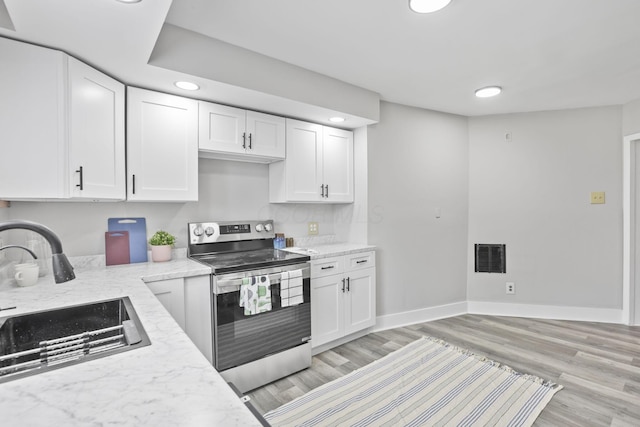 838 Wilson Ave, Columbus, OH 43206 - kitchen featuring stainless steel range with electric cooktop, a sink, white cabinets, light wood-style floors, and recessed lighting