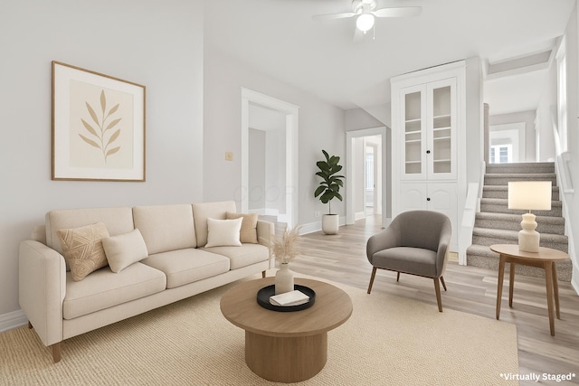 838 Wilson Ave, Columbus, OH 43206 - living area with light wood finished floors, a ceiling fan, baseboards, and stairway