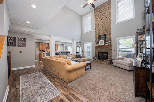 1923 Mallow Ln, Grove City, OH 43123 - living room featuring ornate columns, high vaulted ceiling, a large fireplace, ceiling fan, and wood finished floors