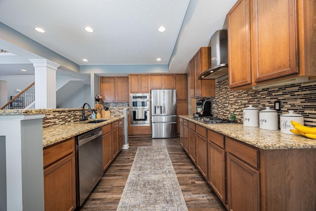 1923 Mallow Ln, Grove City, OH 43123 - kitchen with appliances with stainless steel finishes, a sink, wall chimney exhaust hood, decorative backsplash, and brown cabinets