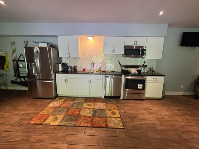 8610 Sadie Thomas Rd NW, Johnstown, OH 43031 - kitchen featuring stainless steel appliances, a sink, dark countertops, wood finish floors, and recessed lighting
