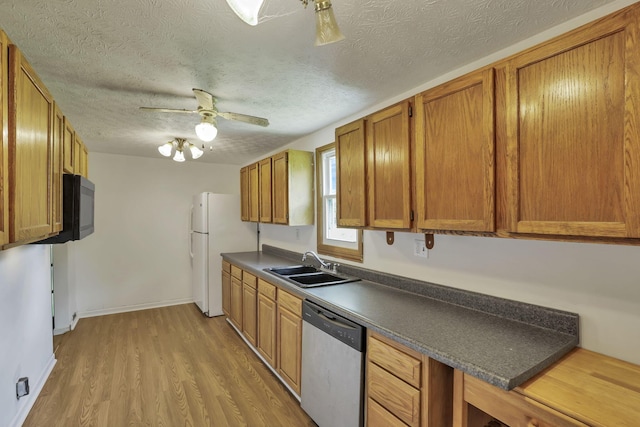 kitchen featuring a sink, brown cabinetry, dishwasher, ceiling fan, and light wood-style flooring