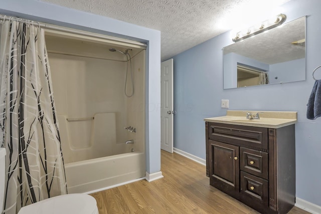 full bathroom with shower / tub combo, a textured ceiling, baseboards, vanity, and wood finished floors