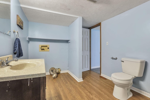 bathroom featuring vanity, toilet, wood finished floors, and baseboards